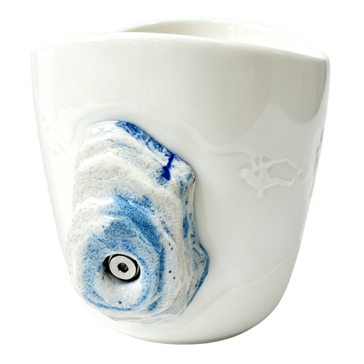 Side view: An off-white ceramic climbing mug, featuring a handle shaped like a 3D climbing hold with blue speckles.