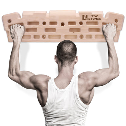 climber training on a wooden fingerboard hangboard to improve grip strength and climbing performance
